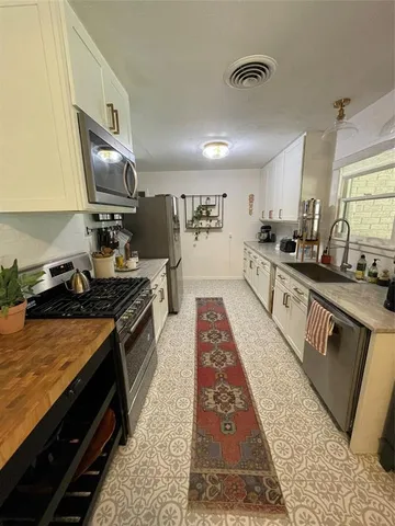 a large kitchen with stainless steel appliances granite countertop a stove a sink dishwasher and cabinets