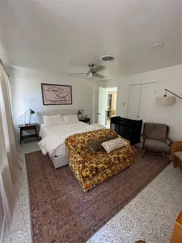 a bedroom with a bed large window and a couch