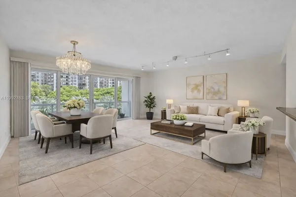 a living room with patio furniture and a chandelier