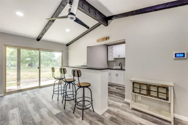 a view of a kitchen with furniture and wooden floor