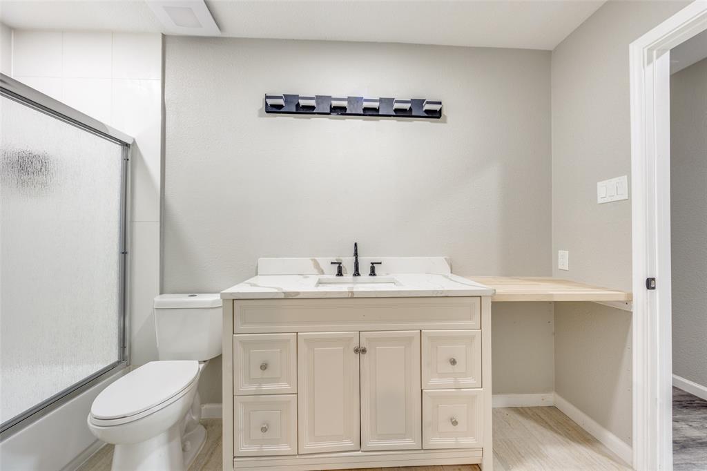 738 Campground Road Sherman, TX 75090 - Photo 30 of 40 a bathroom with a granite countertop toilet a sink a mirror and vanity