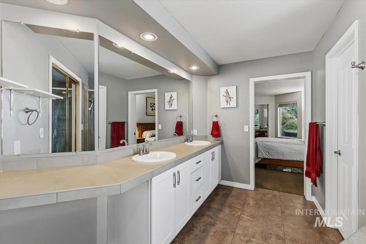 8001 West Innsbrook Court Boise, ID 83704 - Photo 19 of 39 Bathroom featuring a dual vanity with white cabinetry, integrated sinks, and neutral countertops