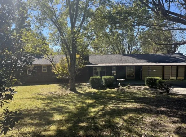 a view of a house with backyard and sitting area