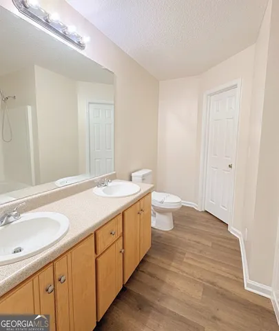 a spacious bathroom with a double vanity sink toilet and a tub