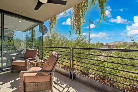 a hallway with painting on the wall and a potted plant