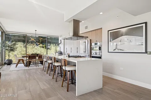 a view of kitchen with stainless steel appliances kitchen island granite countertop dining table chair and a granite counter tops