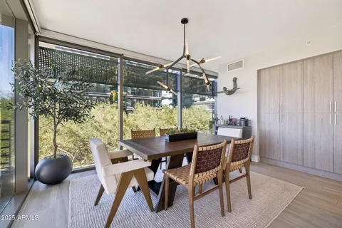 a view of a dining room and livingroom with furniture wooden floor a chandelier