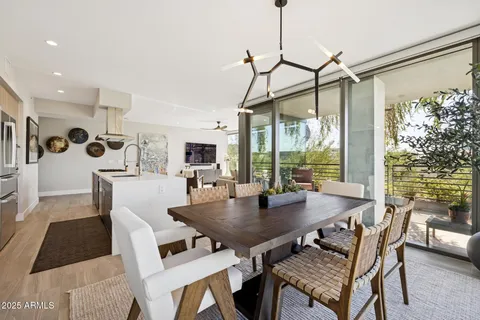 a living room with furniture a flat screen tv and a floor to ceiling window