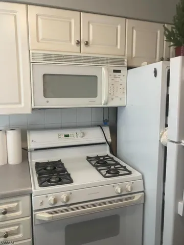 a kitchen with granite countertop white cabinets and sink