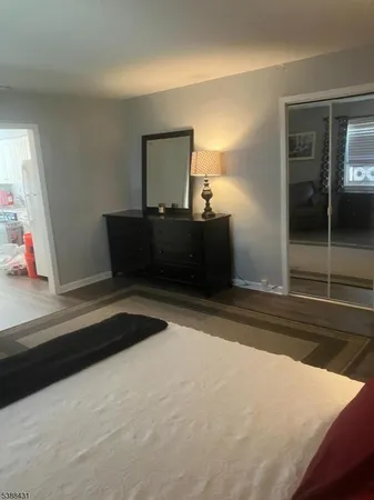 a view of a hallway with wooden floor and a livingroom