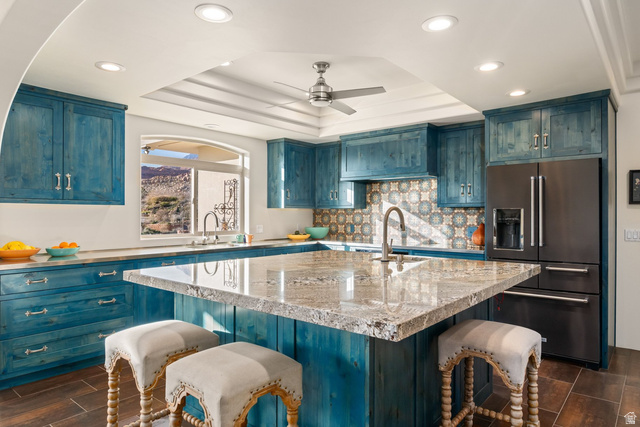 779 South Silver Road Leeds, UT 84746 - Photo 14 of 80 Kitchen featuring a kitchen breakfast bar, wood tiled floors, high quality fridge, blue cabinetry, and a raised ceiling
