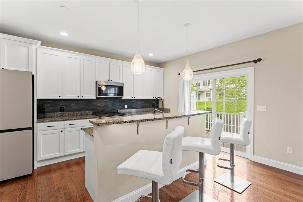 5D Manor Drive, Unit B Hooksett, NH 03106 - Photo 17 of 42 a kitchen with a table chairs refrigerator and cabinets