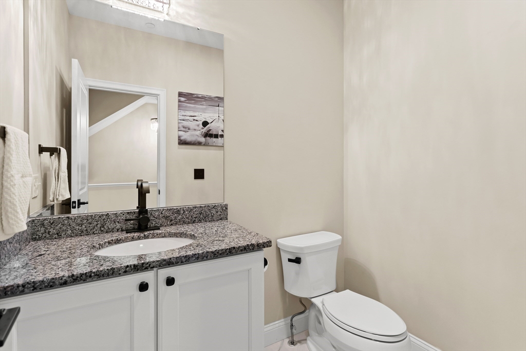 5D Manor Drive, Unit B Hooksett, NH 03106 - Photo 22 of 42 a bathroom with a granite countertop toilet sink and mirror