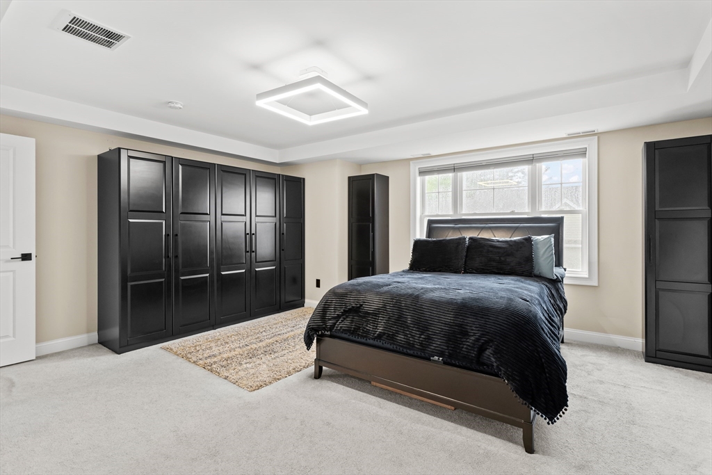 5D Manor Drive, Unit B Hooksett, NH 03106 - Photo 25 of 42 a bedroom with a bed and a large mirror