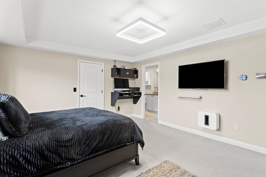 5D Manor Drive, Unit B Hooksett, NH 03106 - Photo 26 of 42 a bedroom with a bed and a flat screen tv