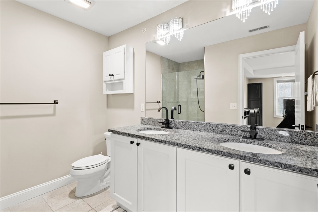 5D Manor Drive, Unit B Hooksett, NH 03106 - Photo 28 of 42 a bathroom with a granite countertop sink a toilet and a mirror