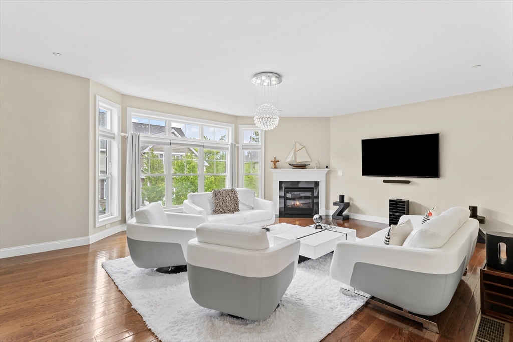 5D Manor Drive, Unit B Hooksett, NH 03106 - Photo 6 of 42 a living room with furniture a flat screen tv and a fireplace