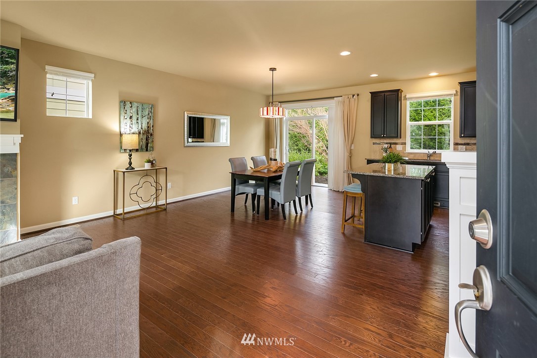 3807 219th Street Southeast Bothell, WA 98021 - Photo 2 of 23 a dining room with wooden floor a chandelier a glass table and windows