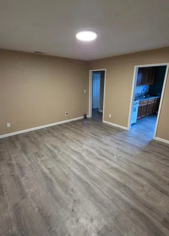 a view of an empty room with wooden floor