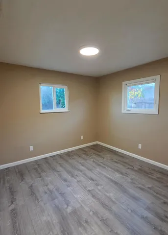 a view of an empty room with wooden floor