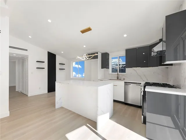 a large white kitchen with cabinets