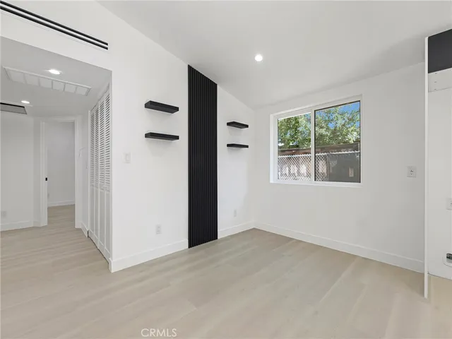 an empty room with windows and closet