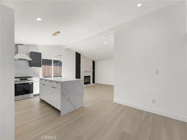 a large white kitchen with a stove top oven