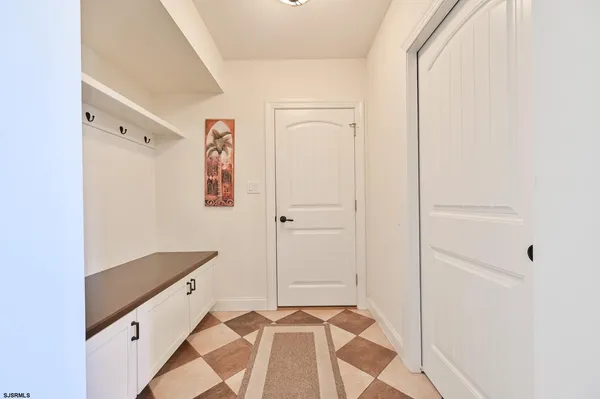 an empty room with wooden floor staircase and windows