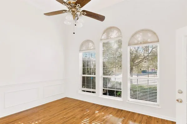 a view of a bedroom with wooden floor and windows