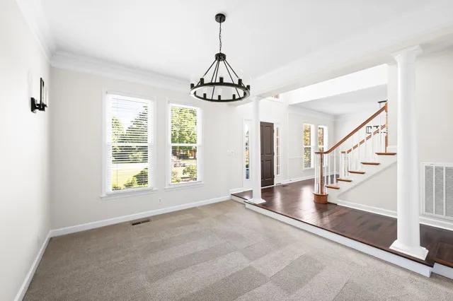an empty room with wooden floor fireplace and windows