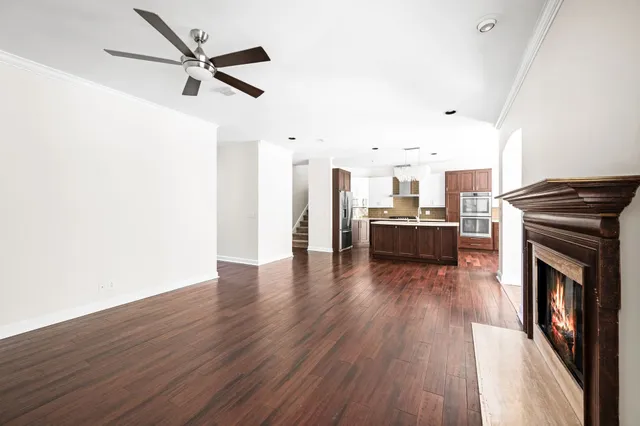 a kitchen with stainless steel appliances kitchen island granite countertop a refrigerator a stove and a sink with wooden floor