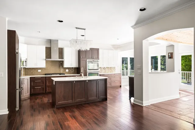 a kitchen with granite countertop a sink cabinets and wooden floor