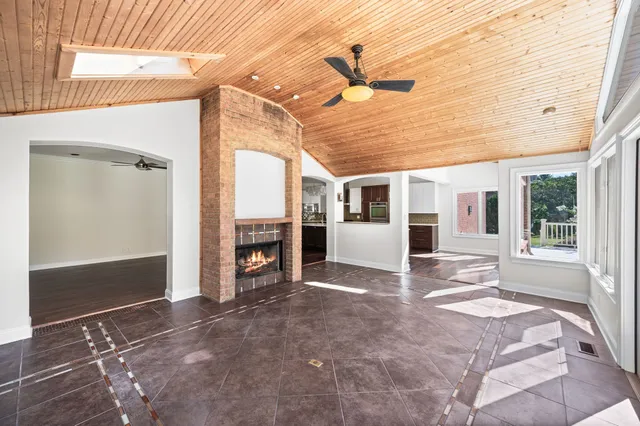 an empty room with windows and ceiling fan