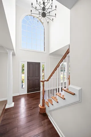 a view of staircase with wooden floor and white walls