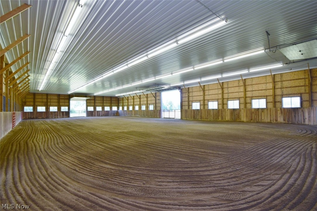 15227 Leroy Road Thompson, OH 44086 - Photo 8 of 50 Indoor riding arena with metal ceiling, ceiling lights and low dust sand.