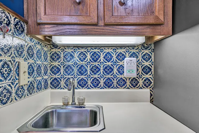 a room with lots of white furniture and wooden floor