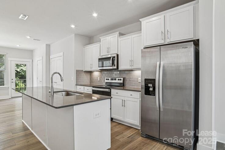 4375 Raleigh Street, Unit B1 Charlotte, NC 28213 - Photo 3 of 19 a kitchen with stainless steel appliances granite countertop a refrigerator a sink a stove a microwave and a refrigerator