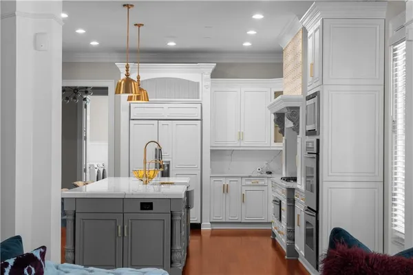 a spacious bedroom with a bed a couch and large windows