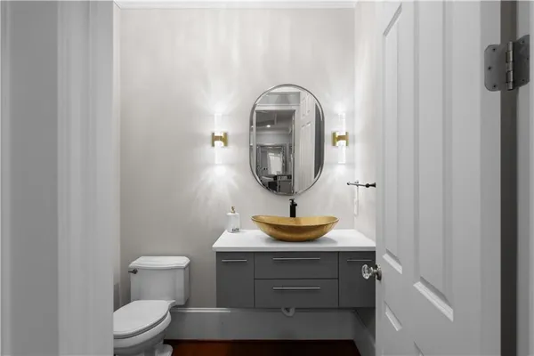 a view of a hallway with wooden floor and a bathroom
