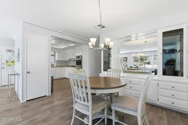 a dining room filled chandelier and wooden floor