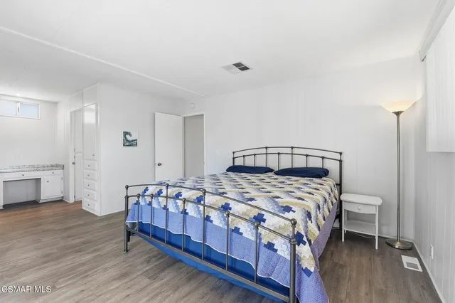 a bedroom with a bed a mirror and a table