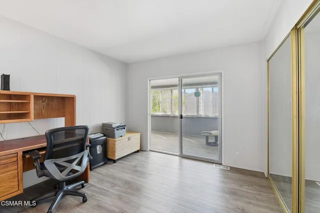 a view of a workspace with furniture and a window