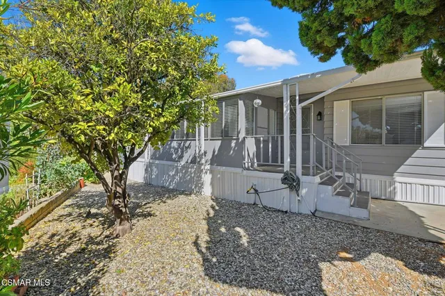 a view of a house with backyard and sitting area