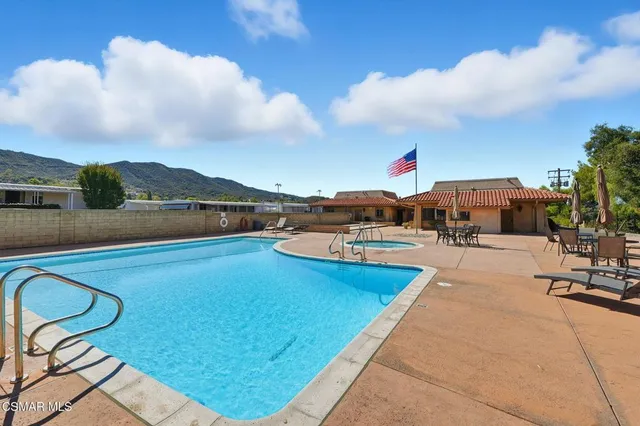 a view of swimming pool with seating area and barbeque oven