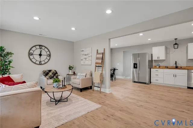 a living room with furniture and view of kitchen