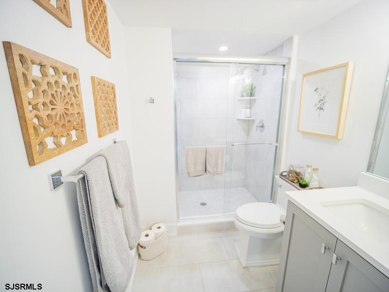 321 6th Street South, Unit 4 Brigantine, NJ 08203 - Photo 13 of 26 a bathroom with a sink a toilet and a large mirror