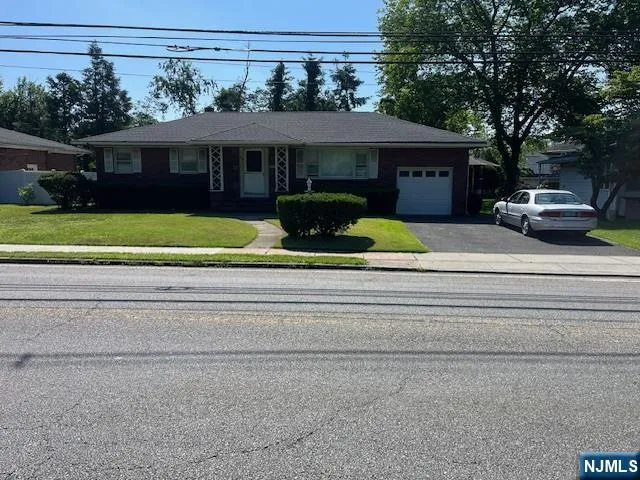 a front view of a house with a garden and trees