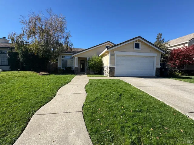 a front view of a house with yard and green space