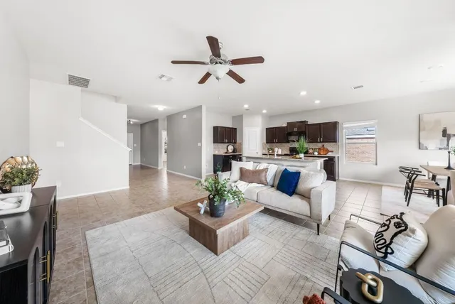 a living room with furniture kitchen view and a potted plant
