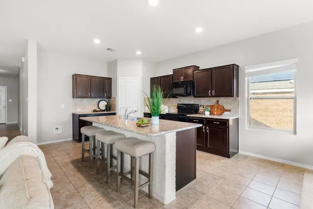 a kitchen with a sink a counter top space appliances and cabinets